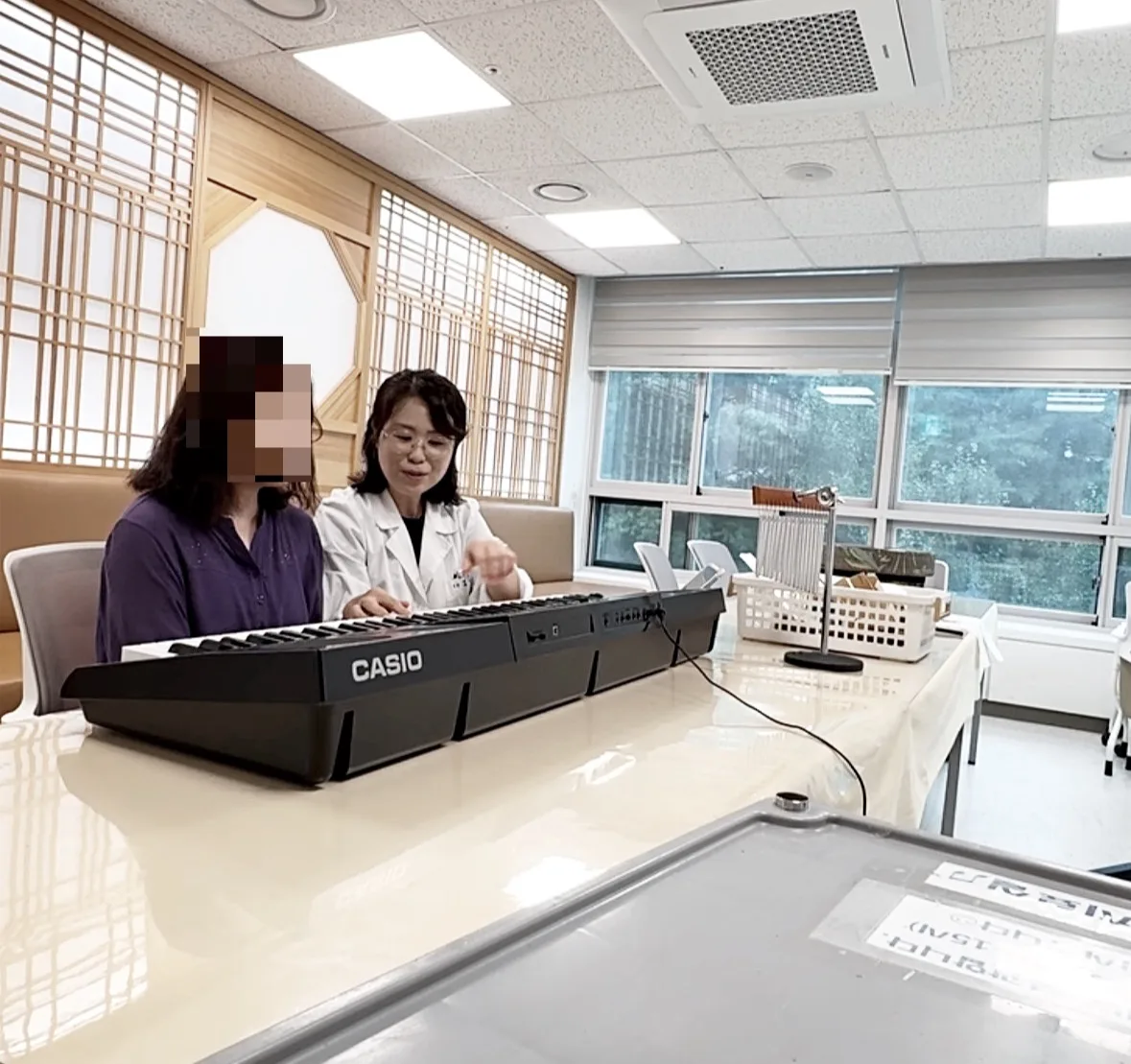 음악치료사가 참여자와 함께 키보드 활동을 진행하는 모습