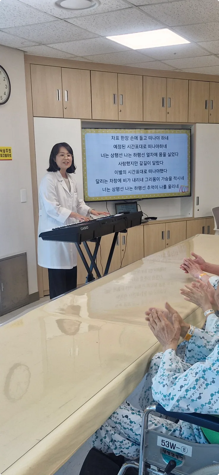 음악치료사가 키보드 연주와 노래 활동을 이끄는 모습