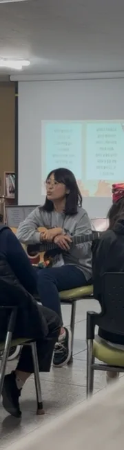음악치료사가 기타와 함께 그룹 프로그램을 진행하는 모습